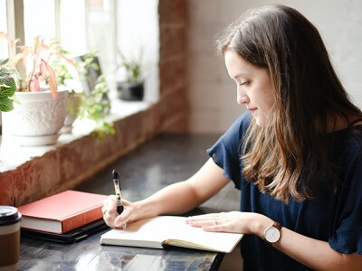woman-write-notebook-room-watch-book-plant.png
