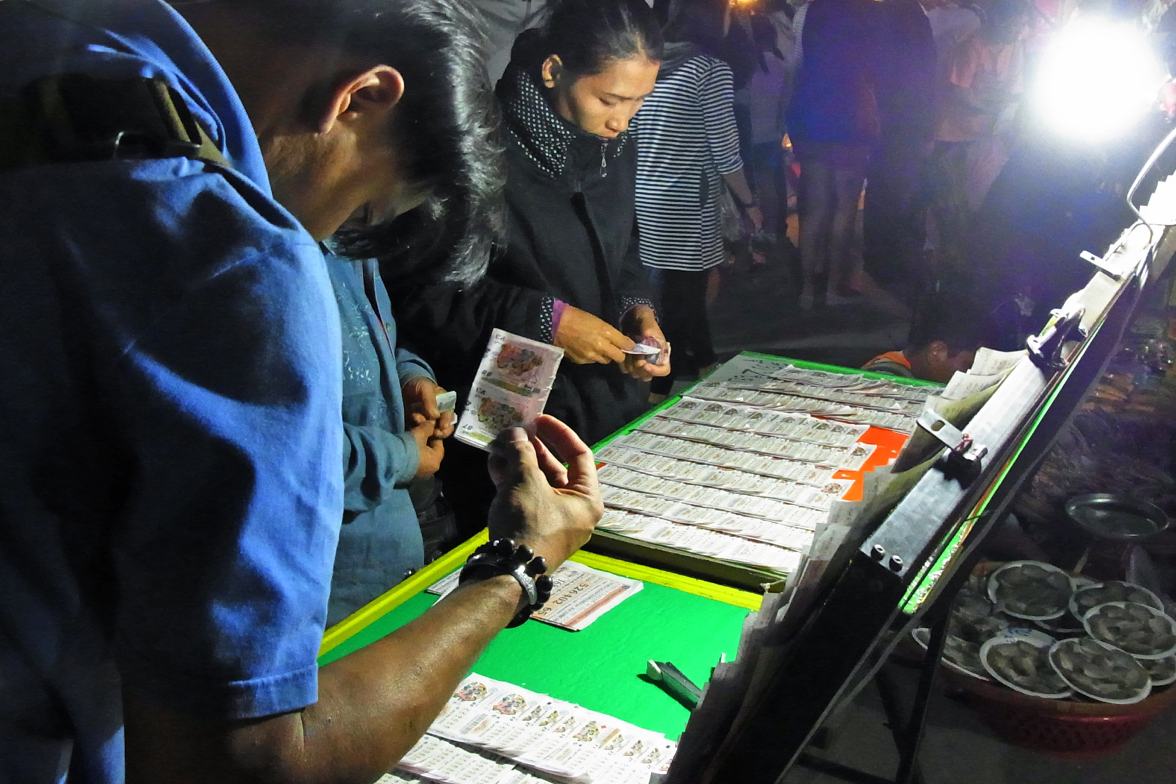 タイの宝くじ売り場で券を選ぶ人々